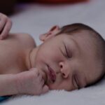Warum schlafen Babys mit den Armen nach oben: verschiedene Erklärungen